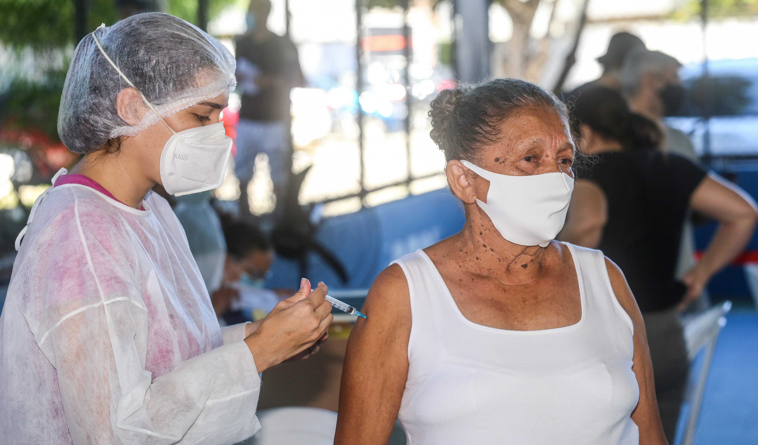 enfermeira vacina uma senhora